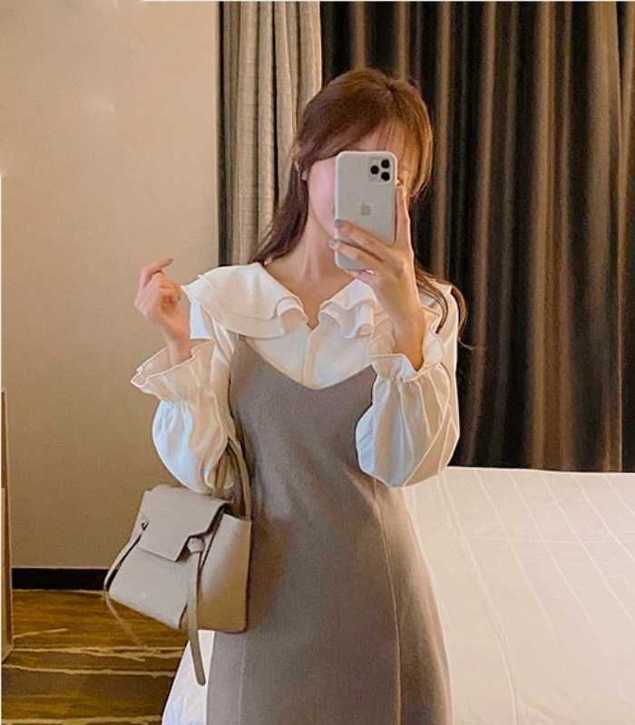 Sơ mi diện cùng đầm 2 dây tạo nên set váy yếm kín đáo và lịch sự